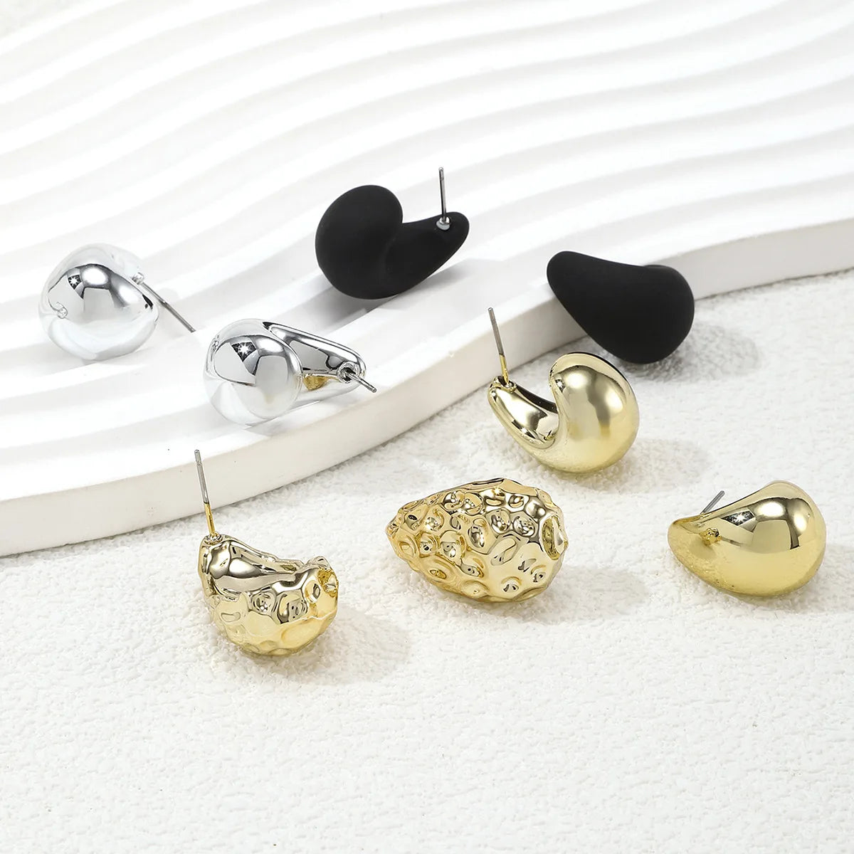 Elegant tear drop party earrings in silver, black, and gold, perfect for any special occasion
